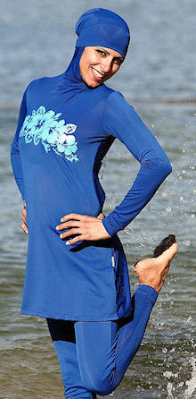 Foto van een vrouw in een boerkini die aan het pootjepaden is. Onderschrift foto: 'De ‘boerkini’: nu nog aan de stranden van Australië, straks ook bij ons? (Fotobron: flickr.com)'